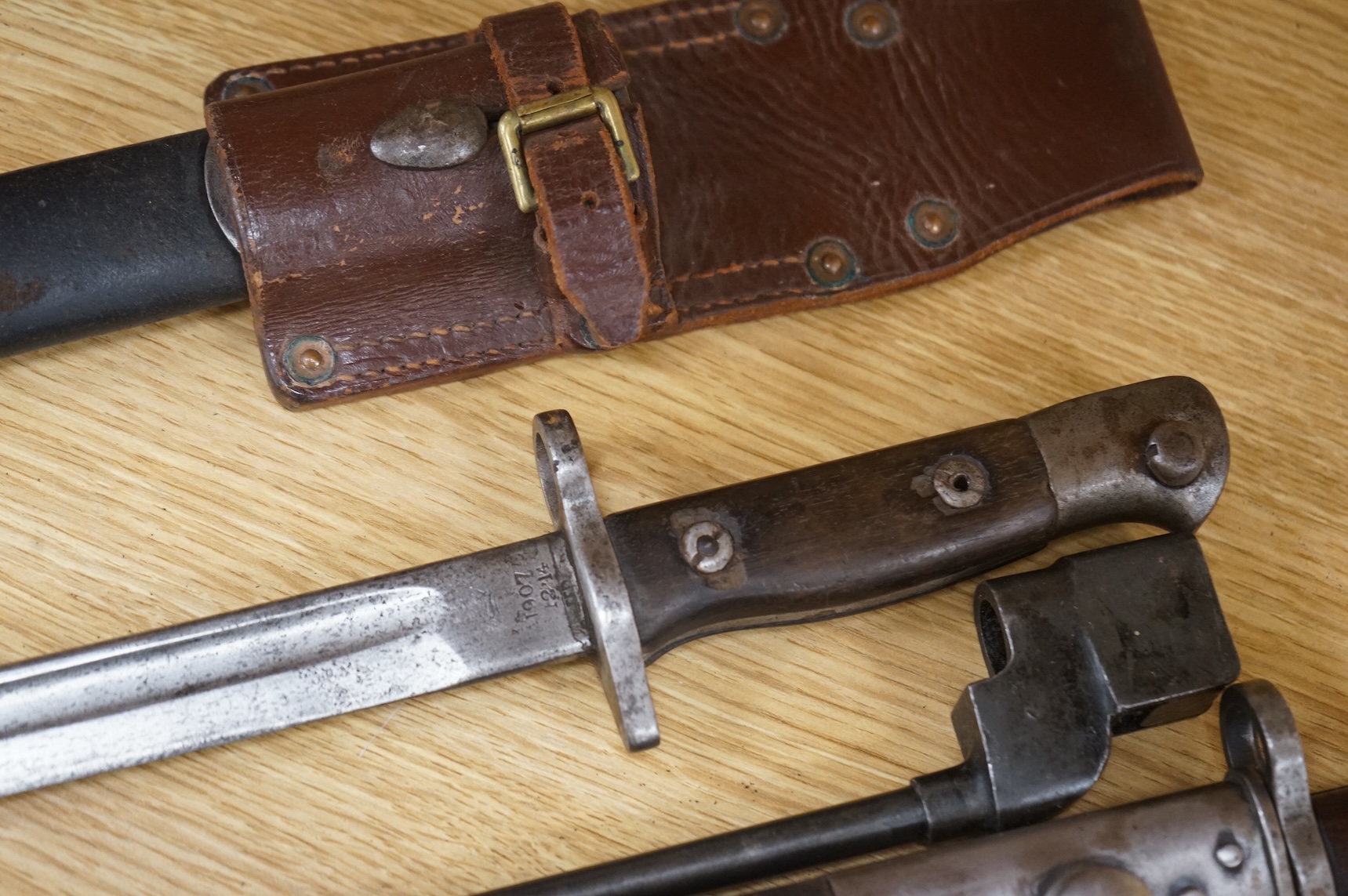 A 1907 bayonet by Wilkinson in its steel mounted leather scabbard, another similar with leather frog, two small British bayonets, a Continental bayonet, and two assorted hunting knives (7)